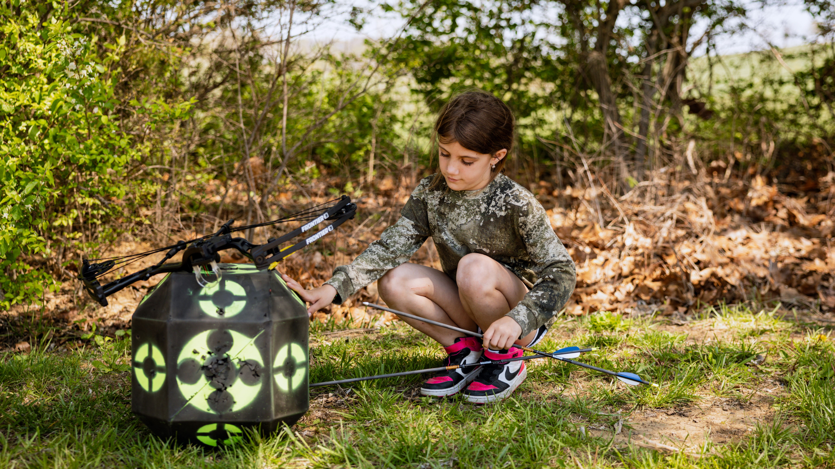 Youth Girl Pulling Gold Tip Lightning Youth Arrow Out of Target